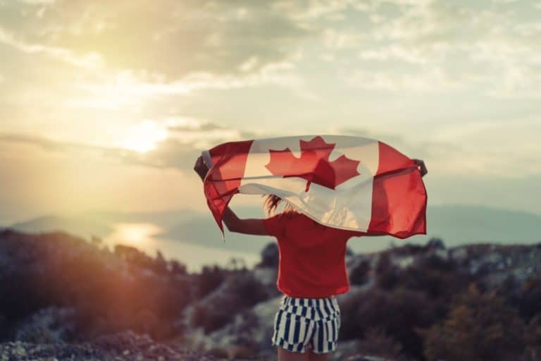 Person holding a Canadian flag, one of the key facts about Canada