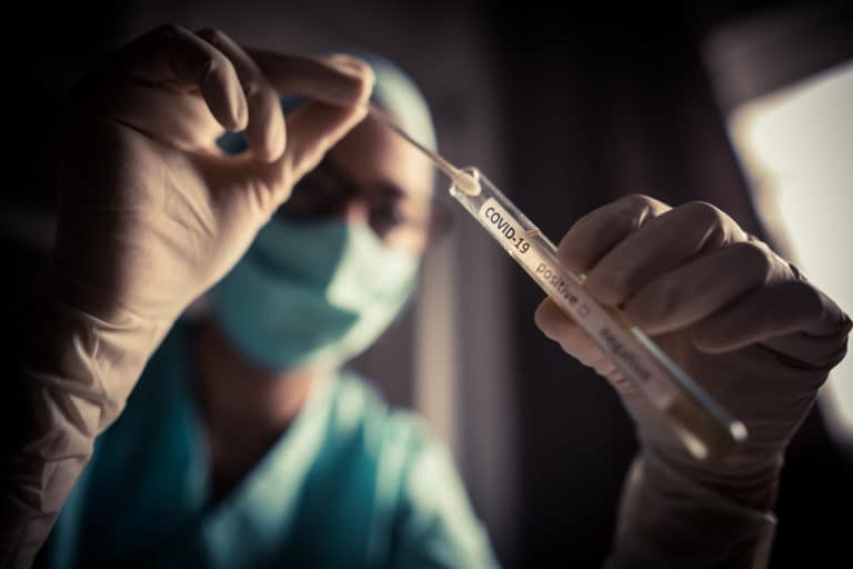 Healthcare worker placing a swab in a tube for coronavirus testing