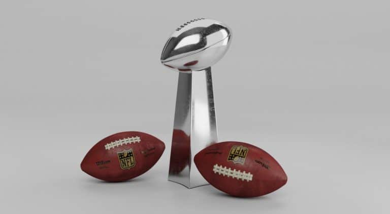 Two footballs and the Super Bowl trophy