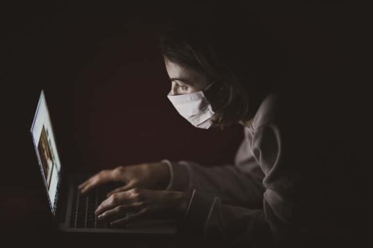 A stressed doctor wearing a mask and staring at the EMR