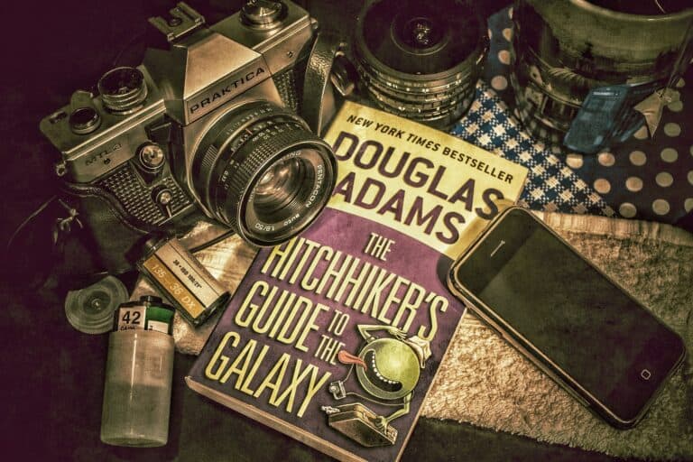 A copy of The Hitchhiker's Guide to the Galaxy next to a camera and smartphone