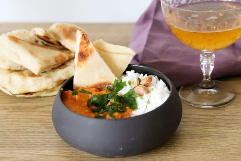 Chicken tikka masala served with rice, naan, and beer