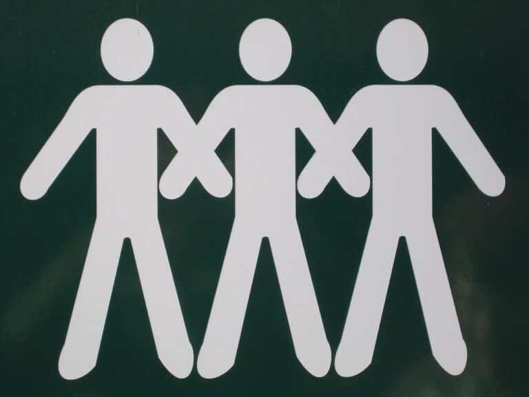 Three men, represented as stick figures, meeting in a city