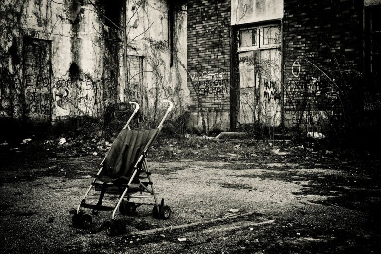 This stroller in front of a run-down building is an example of Urban Realism